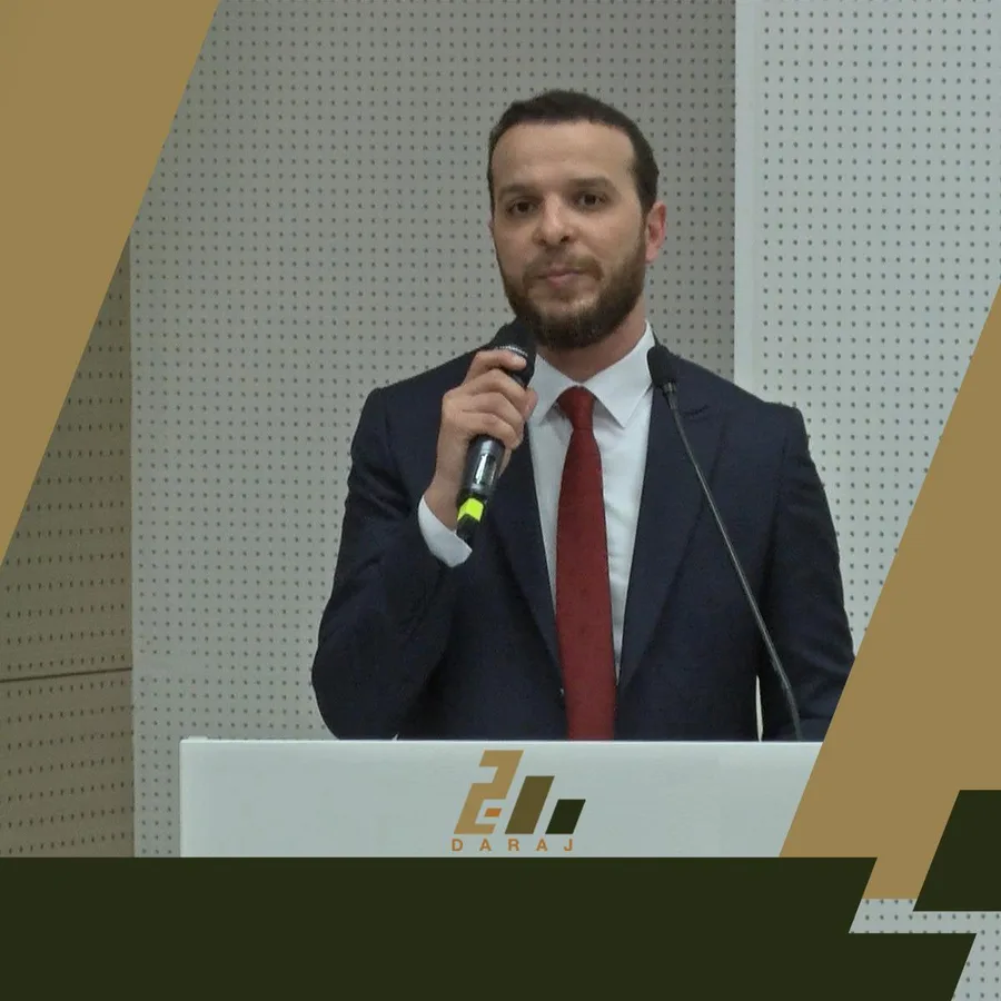 Mohammed Mansour speaking into a microphone at a lectern